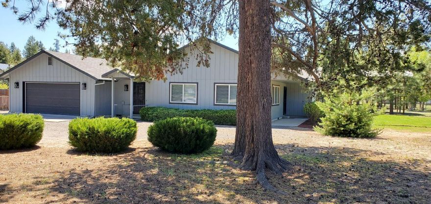 Move-in ready single-level 2 bed, 2 bath, 1568 sq ft home on .91 acres offering comfort, convenience, and space to gather. Recent updates include new security doors, fresh interior and exterior paint, new wall-to-wall carpet, and blinds throughout. Vaulted living room features a rarely used wood stove and large windows framing views of nature and landscaped grounds; 2.5 cords of split wood stay. Kitchen offers generous cabinets and counter space, perfect for entertaining, and opens to the patio/backyard. Primary suite easily fits a king bed, includes walk-in and two extra closets, plus updated bath with new light, toilet, and shower/tub. Second bedroom/office has oversized closet, patio access. 2-car garage has opener and storage. Fully fenced with gated access on two sides. Two powered shops—one hobby, one metal—and RV pole building with full hookups and drain. Extra parking for vehicles/boats/trailers. Sprinklers front/back, heat pump, private well tested clean.