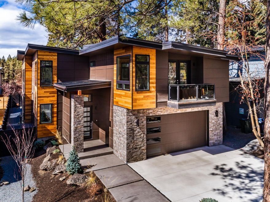 Exceptional mountain modern home nestled in the desirable West Hills of Bend. This home welcomes you with tons of natural light and modern design yet a grounded feel from the mature ponderosa trees surrounding. You will be taken by the unique features of this homes, the 22-foot-high great room ceilings, the industrial roll up door leading into sunroom connecting you to the outdoors, beautiful floating staircase, waterfall quartz counter island, wine fridge, additional industrial roll up door in the kitchen - making it the perfect pass through for all your summertime entertaining. This home offers two master suites. One on the main plus additional master upstairs with 3 other great size rooms. Main level master bath features heated flooring and an amazing steam shower to ease the stresses of the day. This modern oasis is just minutes from Hillside Park, Bend's Downtown, Deschutes River, shops, brew pubs and restaurants plus all that Bend has to offer. Open House Sat. & Sun. 12-3 pm
