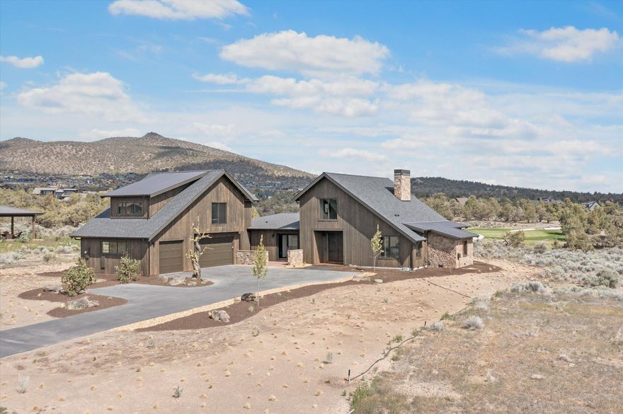 Beautiful two story ranch-style home accentuated with stone accents and stained wood siding on the exterior. Striking views of the 17th Green and Powell Buttes out the back and sweeping Cascade Mountain views from the front patio of this new construction home. 
Inside, you are greeted by a spacious great room with vaulted ceilings and beautifully crafted built-ins in addition to an expansive dining room area. This very open floor plan boasts features, a kitchen with a large slab island that is perfect for entertaining. The primary bedroom is conveniently located on the first floor with a large walk-in closet, oversized soaking tub and spacious shower. There's also a den ideal for an office or guest room that opens onto a paved courtyard, two additional bedrooms, with a full-sized bathroom. A utility room and oversized three-bay garage finish the first floor. 
On the second floor you will find a large bonus/media room that offers tremendous Cascade Mountain views from multiple window