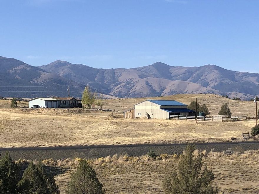 4.96 acres in beautiful Eastern Oregon! 2005 Skyline with 1,404 sq ft, master suite on east end of home for privacy with large closet and walk in bathroom with double vanity and additional storage. Vaulted living room ceiling with open concept. Home has a woodstove, propane furnace and hot water heater, 2 TV's and mounts included, kitchen appliances and washer & dryer are also included, covered back deck, detached 2 car garage with cement slab and power. 43x60 Outbuilding with main bay having gravel floor, 220 power & insulated room. Enclosed lean-to on South side with concrete floor and green house in back. North end has built in chicken coop and stalls. Ample room for parking your toys. Property is perimeter & cross fenced. 1500-gallon cistern. Shared well.
