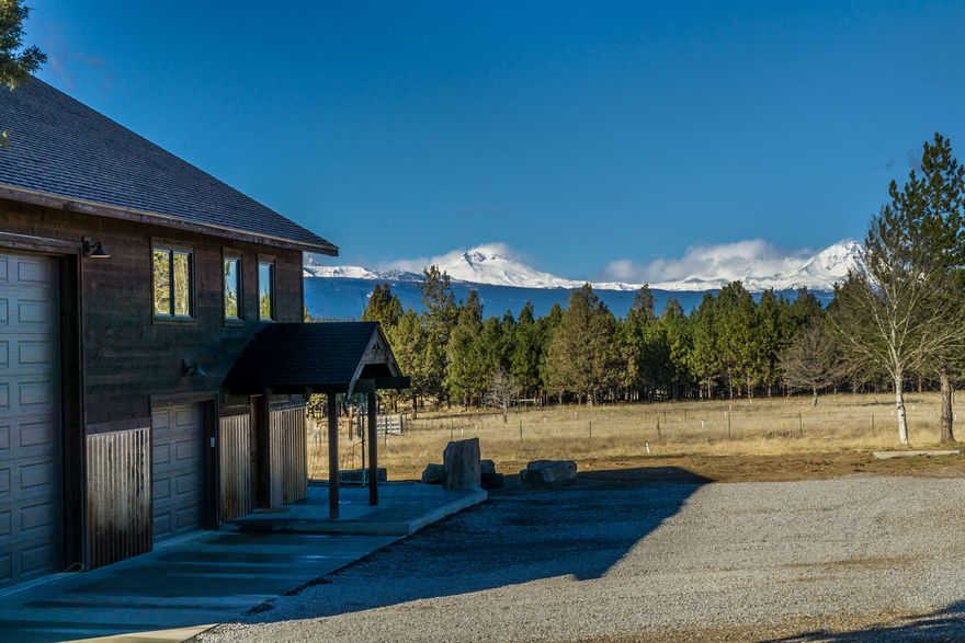 Beautiful Tumalo acreage with Cascade mountain views.  A lovely home and dream shop with gated entry. Upper level living with primary and guest room with full bath. A great room concept with unique finishes, beautiful hard wood floors, granite counters, barn wood vaulted ceilings. The natural light pours in. Lovely deck provides gorgeous mountain views and outdoor living. Lower level has a large bedroom with full bath and laundry that could also be used as a bonus room. Spacious patio for more outdoor space. Plenty of room for all of your toys, hobbies and to expand. Single car garage and 1100+ SF shop with 2 large RV doors. 5 acres of irrigation with a picturesque pond. Great location 10 minutes to Bend or Redmond amenities.  You won't want to miss this fantastic property!