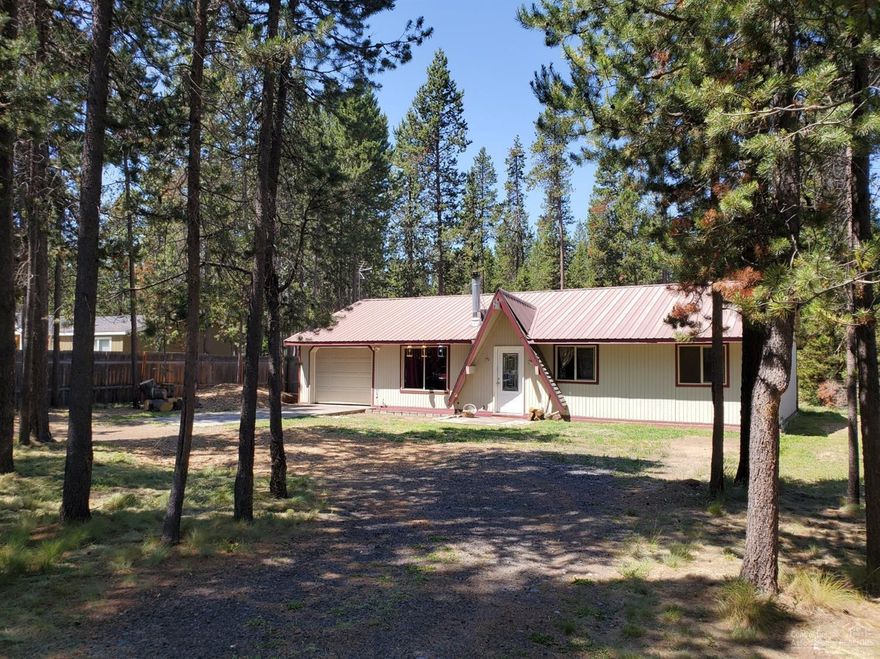 Chalet-style ranch 3 bdrm/1 bath home w/huge, fenced back yard in paved riverfront community of Oregon Water Wonderland with its paved roads, quick access to Mt. Bachelor and the Cascade Lakes and itscommunity water/sewer & boat launch marina! Would make a great rental, starter home! Needs your personal touches!! Large living room w/wood stove w/raised hearth, slate/tile flooring, new carpeting in bedrooms, fresh paint. Lots of windows! Tiled vanity, Kitchen w/maple cabinets, tiled counters. Utility closet. Metal roof! Attached, extra deep Single garage w/shop area, circular drive. RV access/pkg.