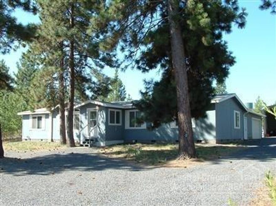 One level manufactured home in Deschutes River Woods. Large garage with shop and covered area for RV. Entered as comp only.