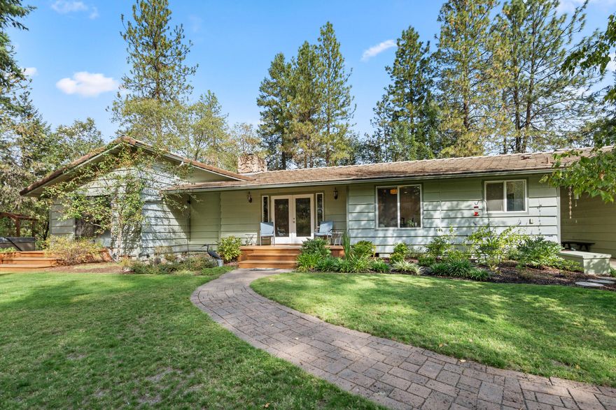 Crisp autumn mornings beneath towering timbers—what a glorious way to begin your day! This private, fenced, and gated sanctuary offers magical gardens, workshop spaces, a greenhouse, and a pristine open concept home designed for easy living. Three bedrooms, two baths, an updated kitchen, woodstove, and a spacious primary suite with walk-in closet and patio access create a cozy yet functional retreat. Enjoy light-filled rooms with views from every window and outdoor spaces crafted by Master Gardeners—lush perennials, fruit trees, and peaceful sitting areas. Step from your primary suite into the hot tub to stargaze or sip morning coffee as the day awakens. There's even a koi pond, woodshed, BBQ area, and countless birdhouses to discover. A true ''heaven on earth'' waiting to be explored—book your showing today!