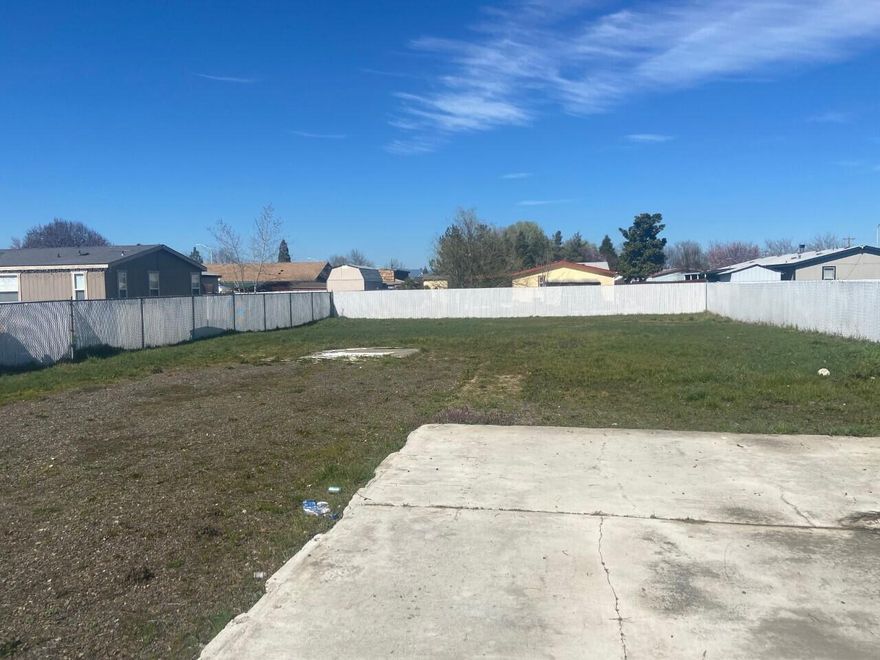 0.23 Acre lot with all utilities into the lot. Sewer, water, electrical. Has a cement slab and driveway already in place Even has a mature tree out front. Great set up to place a Manufactured home or have a home built.