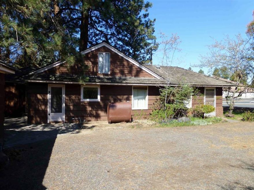 Clean & comfortable vintage home on 1/4 acre corner lot at the base of Pilot Butte. This home features a spacious living room, generous family room, two large bedrooms, a newly remodeled bathroom, a clean & well laid out kitchen, a loft that is great for storage or a small play room & a detached single car garage w/attached car port. The land has many large trees that afford privacy & shade & has potential w/it's generous size & zoning to be utilized for a duplex or other multi-family uses.