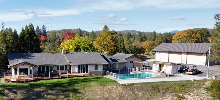 Escape to your own oasis! This magnificent 3,999 sqft home boasts 4 en- suite bedrooms/6bathrms on a sprawling 4.25 acre gated parcel of irrigated land/minutes from town. Gorgeous great room w/vaulted, open beam ceilings w/windows inviting the outside in. FOUR suites, 3 w/direct outdoor access ensuring your family/guest enjoy all amenities they could desire. Primary suite, floor to ceiling windows, jetted tub, shower & large walk-in closet. Formal dining room, large kitchen w/breakfast nook flooded w/natural light and OH the VIEWS! Large laundry area w/sink & dream counter space/cabinets galore leading to large family/bonus room. Entertainers dream w/expansive deck, patio, in-ground solar heated pool. Remarkable 60'x36' shop w/ Dbl bays; 12ft doors, 14ft ceilings, fully climate controlled w/attached bonus living space, kitchenette, full bath, 220-power outlets & RV parking pad! Stroll behind the shop & find a garden & your own chicken coop.