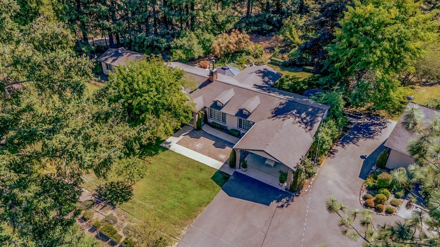 Discover this exquisite 3-bed, 2 1/2-bath home on a 1.87-acre lot, blending luxury and function! Inside, enjoy travertine tile flooring, a cozy woodstove with travertine hearth, and crown molding throughout. The kitchen dazzles with a skylight, while the primary ensuite features a dual-sink vanity and tiled shower. Relax on the patio, the trex decking deck, or hot tub. Outside, a vibrant garden with roses, lilacs, fruit trees, and a koi pond creates an oasis. A heated greenhouse and 16x16 studio building offer creative spaces. The oversized 2-car garage, housing 3 cars, a riding mower, includes 16 upper and 8 lower storage cabinets, 7 ft and 12 ft workbenches, two 6x8x2 fixed cabinets, and a 2x2 bench with storage, ensuring ample workspace. A metal carport could be used as RV storage, and a 9,000-watt generator provides backup power. With a 2-year-old roof and spacious office, this meticulously maintained retreat is perfect for work or creativity. Schedule your tour today!