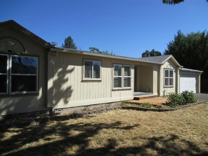 A rare find & affordable. 3 bedroom/ 2 bath with New Carpet & pad. New paint inside & out. Split floor plan, open kitchen and din. rm. (refrigerator, washer & dryer incl.) Propane fireplace in great room, close to hospital. All this on a flag lot. (No Road Noise from Barnett Rd.). The garage has 2 roll-up doors to access back yard, if needed.