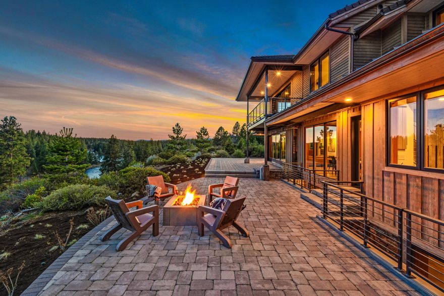 With breathtaking views spanning more than a mile of the Deschutes River, this mountain modern home has a one-of-a-kind westside location with deeded river/forest service access. Every detail exudes exceptional craftsmanship, including high R-value 12'' staggered-stud exterior walls, metal and concrete tile roofs, reclaimed Douglas Fir beams and white oak floors, and Sierra Pacific triple-paned, wood-clad windows and doors throughout. Slide-and-stack floor-to-ceiling glass doors expand indoor spaces to multiple paver patios and elevated decks for relaxing views of the mountains, river, and osprey and eagles in flight. A breezeway rec room has a rock fireplace, and a lower-level entertainment room has natural light and a wet bar. The 2,920sf garage has 21' ceilings, 4 bays—including one 39' deep, 220A outlets, Tesla charger, built-ins, wood stove, full bath/laundry and guest quarters. This sanctuary has a 17.8kW grid-tie solar system, built-in sound, gated entry and private fenced park