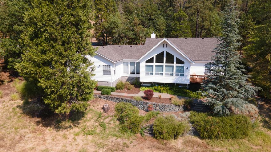 Private, gated, single-level home in the heart of Southern Oregon's lush countryside. Nestled in 8+ acres and just a stroll from Fish Hatchery Park, this lovely 3-bed, 2.5-bath home spans 2,500+sqft. Open-concept layout flows effortlessly from the front door into the kitchen and family room addition, where floor-to-ceiling windows frame panoramic views of surrounding mountains. Landscaping is low-maintenance, w/ drip irrigation & sprinkler system. Recent, extensive fire mitigation work and fire-resistant siding adds peace of mind while a whole-house propane generator preserves comfort and continuity. A detached shop building offers a bonus garage bay & ample storage. Rear gate leads to a large parking area with space for your RV, boat, or trailer. An inner fence surrounds raised garden beds. Built in 1993 and well maintained overall, the kitchen and bathrooms are dated but easy to update to your taste.