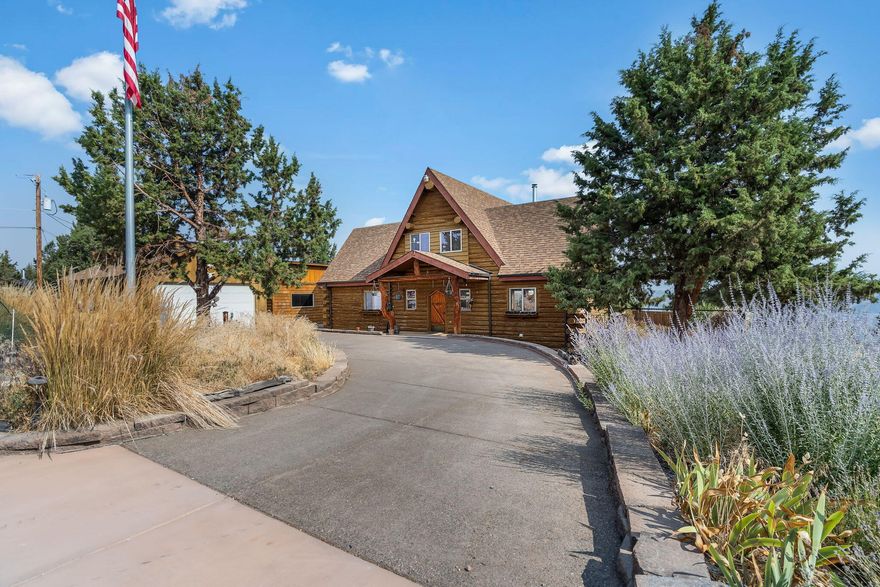 Discover the charm of this classic log home perched on the edge of the Crooked River Ranch canyon, offering stunning eastern views - nothing short of spectacular. Nestled on 1.49 acres, this property embodies rustic elegance & timeless beauty w/artistic touches throughout that evoke a sense of nostalgia. This spacious home features 3 bedrooms & 2.5 baths, perfect for those seeking comfort & style. Central wood burning stove, open kitchen w/log breakfast bar & modern amenities. Primary suite offers a serene retreat, while additional bedrooms provide ample space for family or guests. Open concept plan w/soaring vaults, exposed log beams & lg windows bringing the outside light in. Natural blue pine & log accents, antler chandelier & wrought iron staircase. For the car enthusiast or hobbyist, the property includes two separate 2 car garages, 1 offers added single car storage/workspace. Native landscape & pond, partially fenced. Don't miss your chance to enjoy this unique rim property.