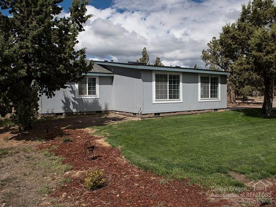 Between Bend and Redmond on 2+ acres. Attractive 3 bedroom, 2 bath home w/skylight & painted in 2016. The 30X36 shop has concrete floor, 220 electric, partially sealed with overhead storage & insulation, a wood stove, a large drive thru door on each end. The 40X60 pole barn has gravel floor, 50 amp electric & 2 12-14 enclosed & insulated storage rooms. The property also has a 12X19 shed-carport as well as a RV dump site. County records show a 1500 gallon septic tank. Sale includes Tax Account #202777.