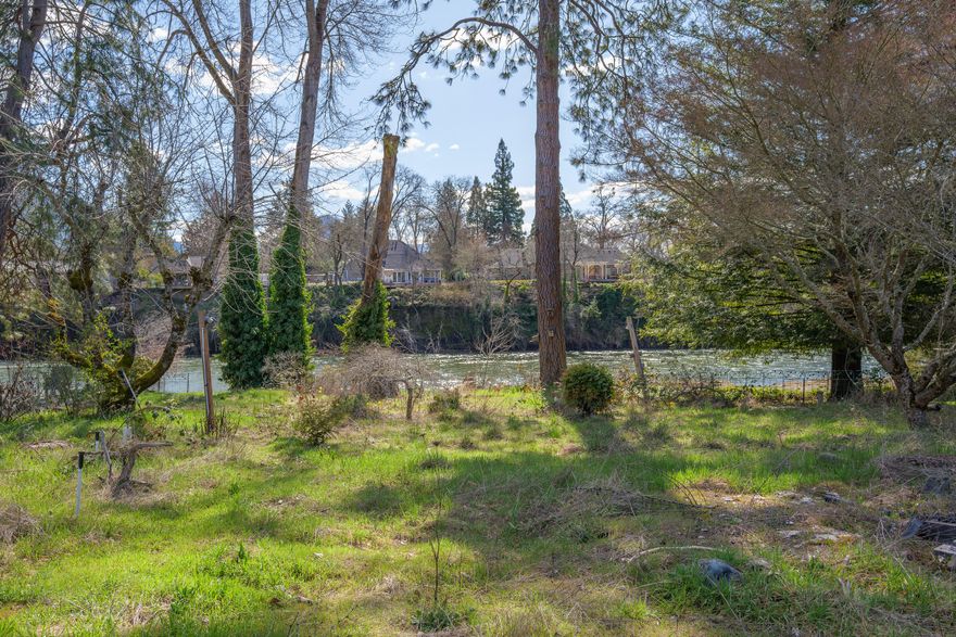 Nestled along a picturesque stretch of the Rogue River, this rare and breathtaking .33 acre parcel offers low-bank river frontage with easy, usable access. A gravel bar with a sandy beach lies between the homesite and the river, creating an ideal setting for relaxation and recreation.  Situated down a quiet paved drive within a small, peaceful community, this property offers the tranquility of country living while still being within city limits. This is an exceptional opportunity to own one of the few remaining buildable riverfront properties in the area. The lot is already equipped with grid power and city water and sewer at the property line, making it ready for your dream home. There was previously a home on the property. The seller has removed the old structure and has engineered plans that mee county specifications for a new build, which are available for purchase separately.  This is an impressive and rare find - don't miss your chance to own this remarkable riverfront property.