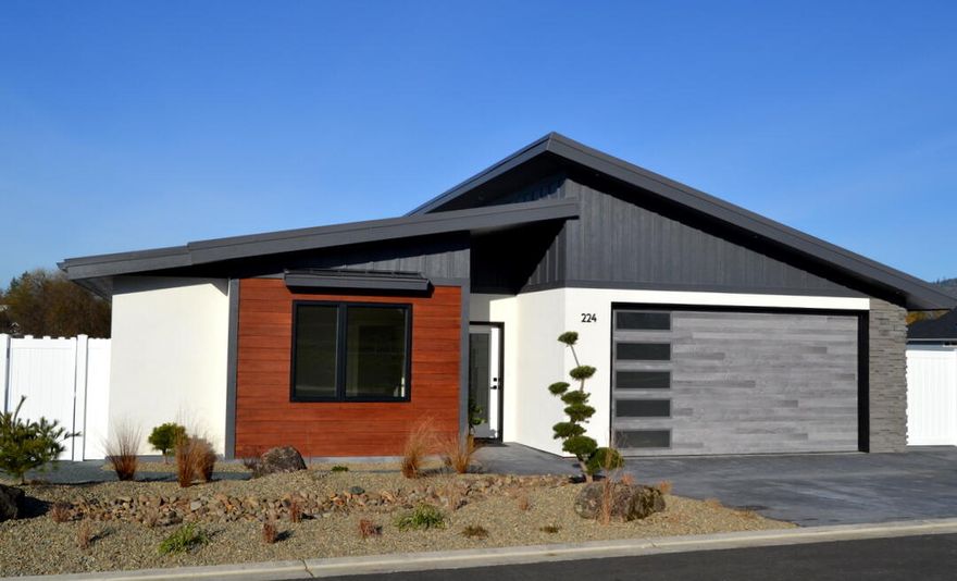 This builder has created something truly special: a thoughtfully designed modern-style home offering exceptional upgrades and low-maintenance living. Highlights include a 50-year standing seam metal roof, stucco and cement plank siding, and a Northwest-inspired exterior accented with distinctive  quartz stone details. Inside, the home continues to impress with a striking linear fireplace wrapped in stone, creating a warm yet contemporary focal point in the living space. The Euro-style kitchen is anything but ordinary, featuring upgraded appliances, clean modern lines, and a dramatic quartz waterfall island that elevates both style and function. Throughout the home, sharp door profiles and refined finish work reflect the builder's pride in craftsmanship and attention to detail. Attractively priced for the square footage and quality offered, this home delivers far more than typical tract housing—providing exceptional value in a desirable location close to everything.