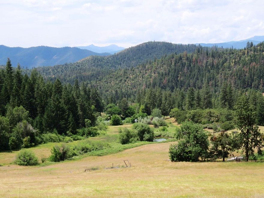 72 acre private paradise located just over 8 miles from historic Jacksonville Oregon. EFU zoned with aprx 34 ac irrigation water rights that can be set up under gravity flow. There are two yearly ponds fed by the creek and numerous springs and two well spring cisterns. The property is tucked in its own valley and surrounded on 3 sides by vast BLM tracts. The views of open pastures, timbered hillsides (some marketable) and mountains create a breathtaking spectacle. Abundant wildlife call this private sanctuary home. There is an old homestead house in fairly poor condition with power, phone line and well that anchors a home site for the new owner with many great locations with stunning views for a new house. There are also a number of dilapidated out buildings. The land with south and westerly slopes would make an excellent vineyard or any number of crop growing possibilities. This is a real jewel and parcels like this are rarely available so act quickly.