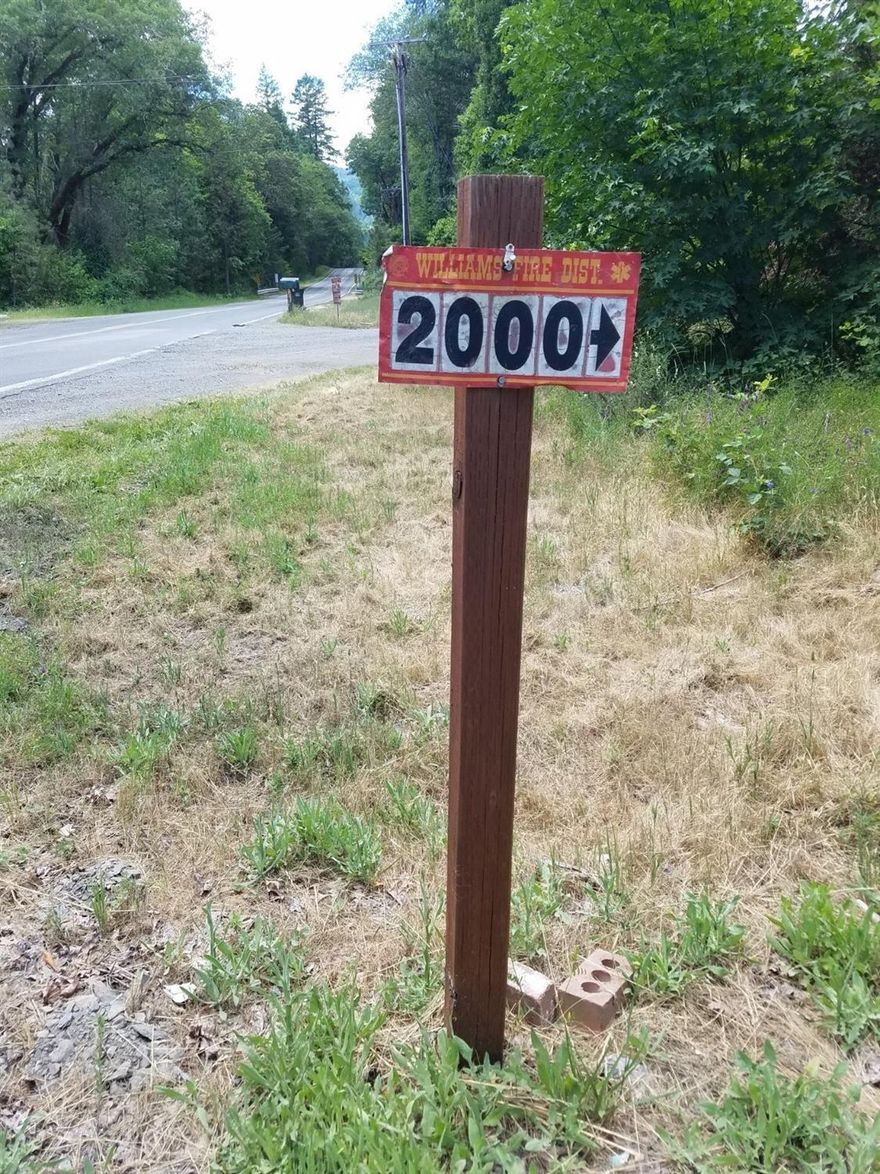 Mostly wooded, sheltered property with 1974 3 bedroom, 2 bath double-wide manufactured home in Williams. Value mostly in the land. When drilled, the well shows 12 gallons per minute.