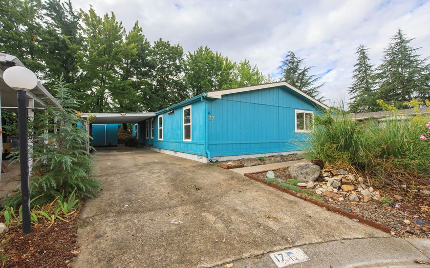 This 3 bedroom 2 bath home in Ashland's Tolman Creek all age park it backs up the  YMCA soccer fields. Convenient location  close to shopping, Dining , bus stop, YMCA and freeway exit. Open floor plan, w/vaulted ceilings and Skylights.  There's a good amount of living area with a family room and a living room. The dining room and laundry room are off the kitchen. Two bedrooms and guest bath on one side, primary on the other side. Primary has a walk-in closet and en-suite with walk-in shower. Covered carport, 2 storage sheds, terraced back yard and covered patio. This home is a diamond in the rough waiting for someone to make it shine.