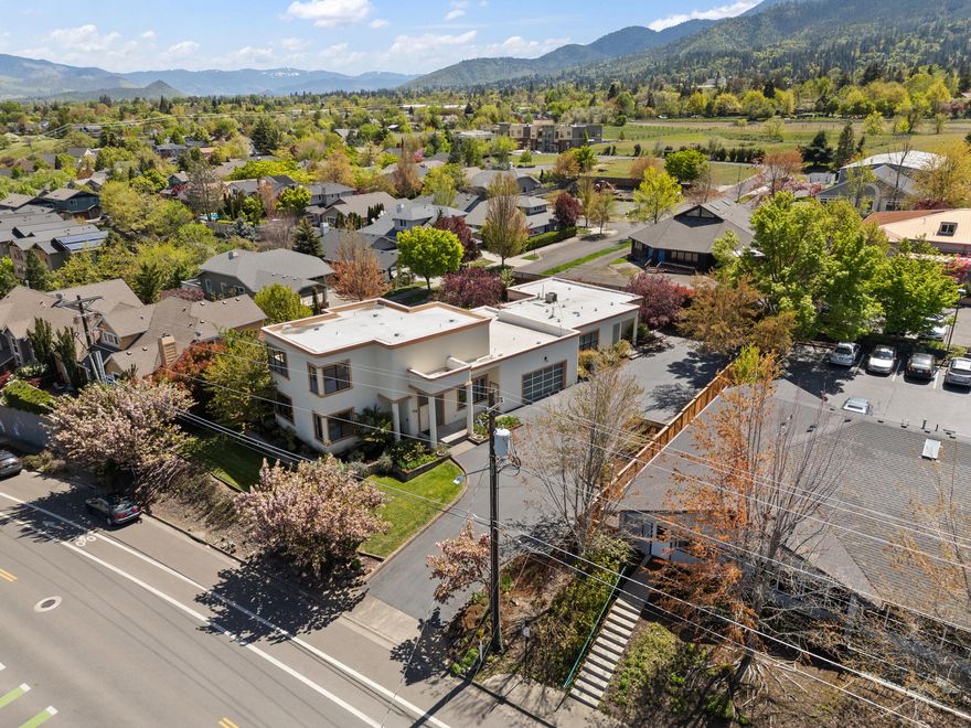 Unique opportunity to own a private 4,560' compound, walking distance to downtown Ashland. The building is divided into two units: 394 Hersey, a two story 3,124' 3 bed/2 bath with a bonus room and garage, and 396 Hersey, a 1,436' ADA accessible 2 bed/2 bath with it's own parking and entrance. The main home opens up to 23' ceilings and a spiral staircase. The large living room provides abundant space for entertaining, and substantial natural light. The dining room features large columns and a Murano chandelier. In the kitchen, you will find a gas range, double ovens, and a pantry. Upstairs is the primary suite, complete with mountain views, a private balcony, spacious bathroom, closet, and bonus room. In the second unit, you will find Brazilian Cherry floors throughout, and a custom kitchen with granite countertops.
E-1 zoning allows for flexible use between residential and business purposes. Short term rental use is permitted with conditional use permit. Please see 3D tours attached.