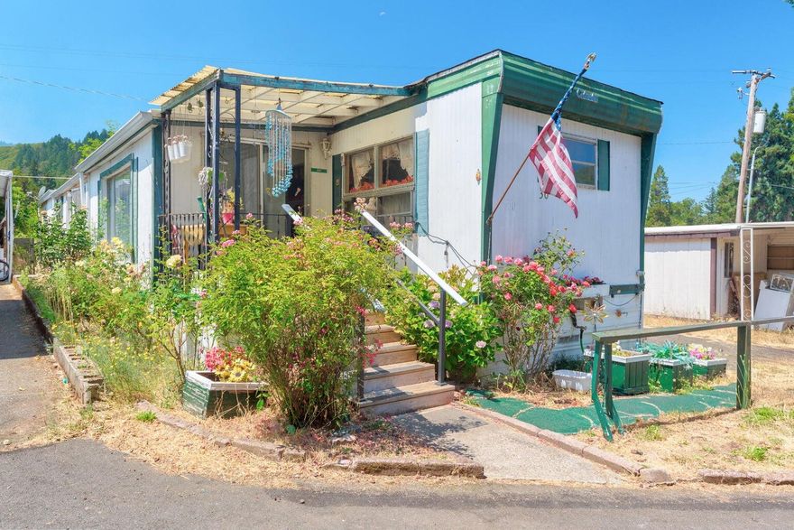 Cozy two bedroom 1 1/2 bath, 1965 mobile located in all ages, pet friendly park. Added on bonus and laundry room not included in the square footage listed for this double wide. Portable A/C, washer (cold water only), dryer, two sheds, and fridge included in sale. Beautiful mountain views with Rogue River right across the road. Conveniently located between Grants Pass and Rogue River.