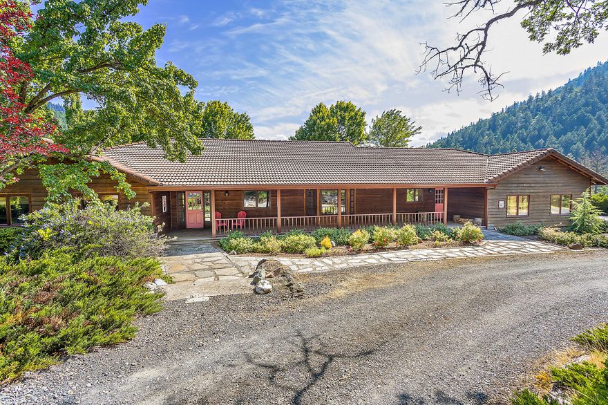 Make your dream a reality with this amazing property. Located in the Applegate Valley, this 59 acre estate has a unique terrain layout that must be seen to be appreciated. The lower section along Thompson Creek is utilized by the current ownership as a turn-key professional horse operation (Hidden Meadows Dressage) with a a 200x60 covered lighted arena, two stall barns (one with living quarters), two outside arenas, many paddocks with run in sheds, a pond and hay barn. The upper area of gently sloping fields and forest land keeps the home and pool very private and affords the fabulous southern views towards Grayback Mountain. The slope/aspect combined with the elevation (1600 ft) would favor several wine varietals for those looking to be established in the Applegate Valley AVA. The home is a single story ranch with tile roof. It features a beautiful covered porch, large rear deck, 5 bed,3.5 bath, gorgeous master suite and stone fireplace. Zoned EFU/FR, has irrigation and back to BLM.