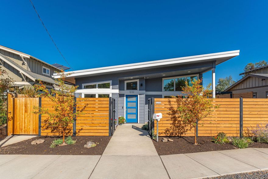 Discover this sleek, modern home on Bend's west side, just steps to shopping, restaurants, and the Deschutes River. Designed for energy efficiency and low-maintenance living, this home boasts 8 KWH solar panels, concrete floors with radiant heat, triple-paned windows, Navien tankless water heater, air filtration system, & smart home features. The single-level main residence with 2 bedrooms, 2 full baths, and built-in office area is bright and airy with generous windows and vaulted ceiling. The expansive 1 bedroom/1 bath ADU above the garage is perfect for guests, rental income, or multi-generational living, with access from the main house or outside. The oversized garage is ideal for outdoor enthusiasts, with room to park a Class B RV and store all your gear. The low maintenance outdoor space has a south-facing garden area, patio with pergola off the dining area, and is wired for a hot tub. Enjoy the perfect blend of style, convenience, and sustainability in a sought-after location!