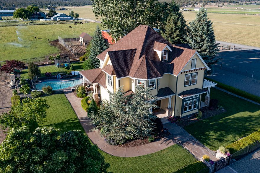 Luxury country living at its finest! This stunning Victorian 4 bed, 2.5 bath home checks all the boxes! The new inground, heated pool is the perfect place to enjoy  views of Grizzly Mt. at sunset. Views of Sisters from both front & back covered porches. Nestled in the farmlands, minutes from town, this irrigated acreage also offers beautiful landscaping w/a sprinkler system that keeps everything green all summer. Large riding arena,  80'x63' barn/shop w/ 4 stalls & 6 roll up doors. Plenty of room for horse trailers & RVs. Property is fenced w/a automated entrance gate. New chain link fencing- kid friendly play area. The home has fresh paint inside & out, new LED light fixtures throughout. New carpeting & premium washer/dryer on second floor. You will love the custom country kitchen, butcher block island countertop & new ceramic sink. Formal dining room-just the right touch for family dinners.  Quick possession available. Sellers will consider contingent offer.