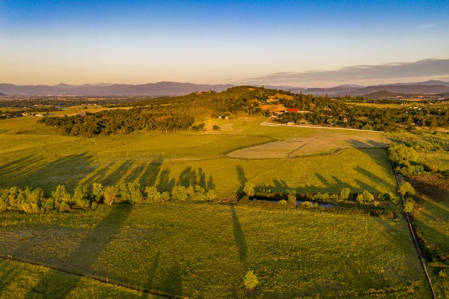 Welcome to Stevens Road Ranch, featuring incredible views, convenience to town, two beautiful residences, a historic barn, shop, oak savannahs, pasture, & 37 irrigated acres. Facing Mt McLoughlin, this extraordinary property provides the perfect balance between the expansive beauty of rural life and the delights of modern living. The main home boasts over 3,000 square feet of high-end finishes, with an open floor plan, grand vaulted ceilings, spacious living room and well appointed chef's kitchen. A lavish master suite with Italian marble, 2 guest bedrooms, laundry room, & guest bathroom round out the main level.  Upstairs is the large recreation room and full bath. Surrounded by charming floral plantings and stunning maples, the outside living space includes 2 patios, slate flooring, & water feature. The 1,700+ SF log cabin has an inviting 3 bed, 3 bath floor plan, large wrap-around deck and great views. Just 2 miles to Eagle Point and 12 miles to the Medford International Airport.