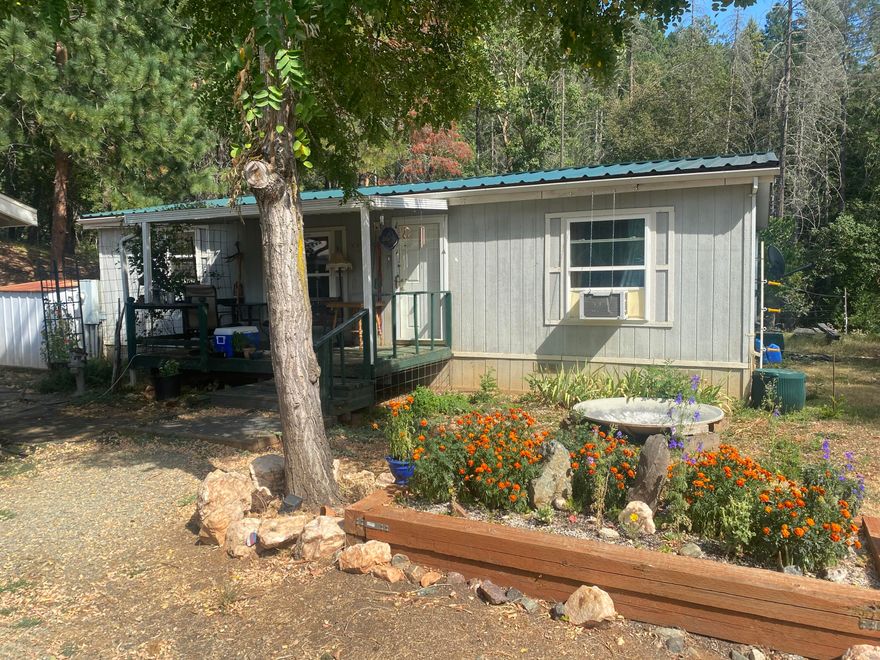 Nestled on 11.3 acres, this charming double wide manufactured home features 3 bedrooms and 1.5 bathrooms with spacious floor plan. Ample sized kitchen with newer appliances and plenty of counter space and storage. Large primary suite with sliding glass door that leads to deck and garden area. Detached 2 car garage with bonus room for extra storage. Upgrades include newer metal roof. Enjoy true country living with great trails leading throughout the property. Wood burning furnace and solar water heater with generator hookups will never leave you without heat or water. Secluded but still close to I-5, This is a must see!