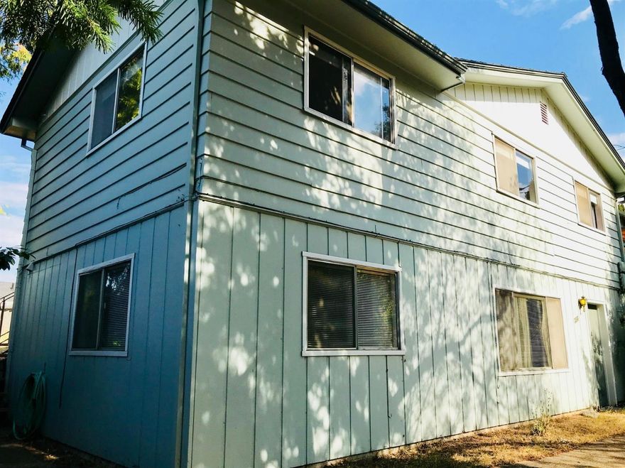 Desirable location close in to downtown and not too high in the hills! This home is situated on a good-sized lot with mature trees and mountain views. It'll be worth doing what's needed to realize its potential. Sold as-is. The main level has office space/family room sharing the dual fireplace with the living room; 3 bedrooms, 1.5 bathrooms, mostly hardwood floors on this level. Attic has storage space. 1-bedroom/1 bathroom living quarters are on the lower level-- not legally permitted as a rental. Laundry and furnace rooms are on that level and have been shared by occupants from the whole house. The useable grassy yard wraps around like a wide L''. 2-car carport with storage, more parking off-street, garden shed. Roof is about 10 years old, relatively new water heater. Sellers have owned it for 30 years and raised their family here.