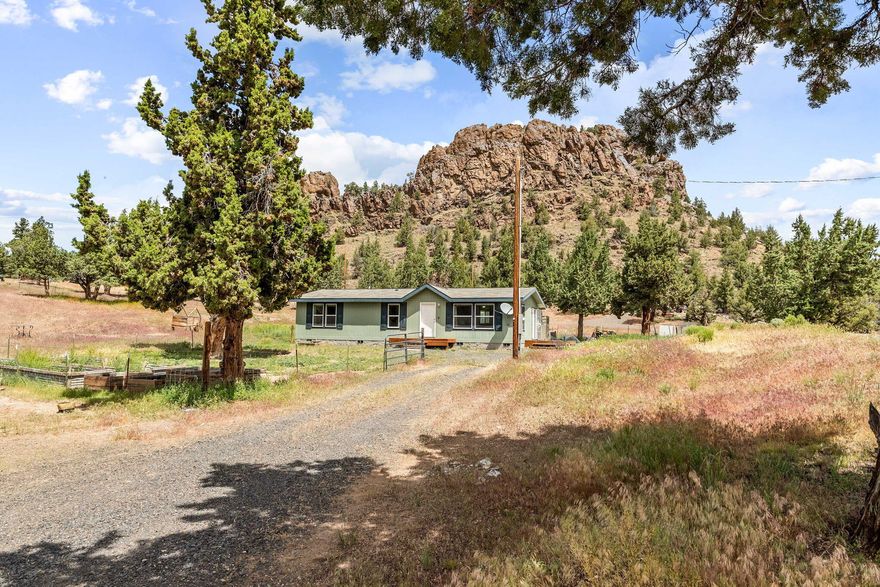 Nestled in nature, this 3-bedroom, 2-bath home has stunning rock formations just outside the back door. Imagine sipping coffee while marveling at the formations,
watching wildlife abound, and catching the sunlight bounce off the surface. Just a few short minutes to Prineville Reservoir where you can enjoy boating, fishing,
swimming, kayaking, and more. The spacious living area features large windows that flood the space with natural light, creating an open and airy feel. Brand new laminate
wood flooring in dining room, kitchen, laundry, and one bath! Lg primary bedroom w/attached bath with oversized vanity, & walk-in shower. Open concept kitchen w/ample
counter space and wood cabinets. Just off the kitchen is a laundry/mud room. Step out the back door to lg shop w/attached carport, storage, & full RV hookups! Nearly one
acre of land w/room for animals, this remarkable property offers ample space and privacy for you to enjoy for years to come.