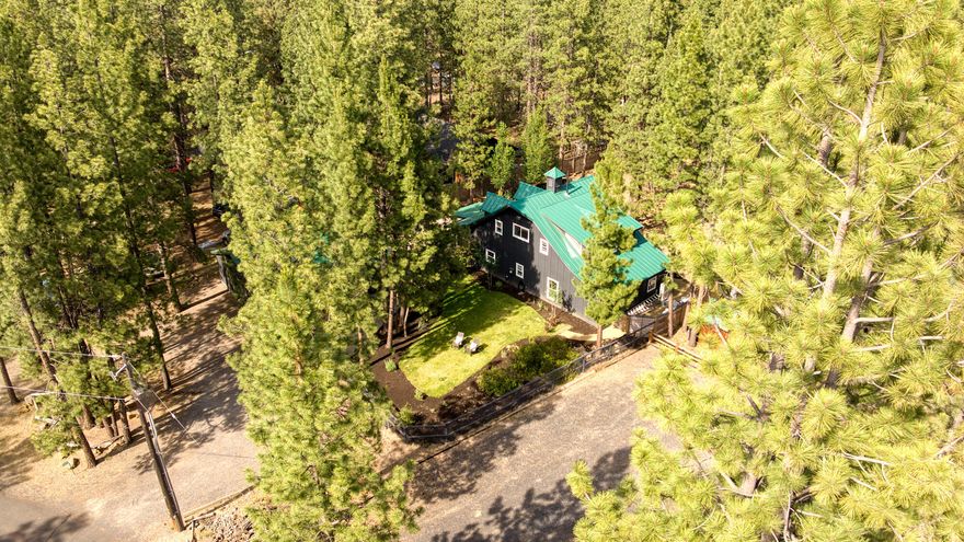 Prime, end of the road location backing up to the lava flow. A highly desired, coveted spot away from traffic noise and cross streets. This special property radiates vacation vibes and warmth. Choose from multiple outdoor spaces to host gatherings or tuck into for an afternoon nap under the pines. Dormer windows bring visual interest and functional appeal to the 5 year old home, adorned with a metal roof. Inside, wood beams bring balance to the clean color palette while abundant picture windows bring the outdoors, in. The floor plan offers both a family room and living room, and useful built-in seating in the dining room. At the rear of the property a basalt lava flow provides privacy and cool optics and extends all the way to Lava Butte. Close to town quiet settings like this are getting difficult to find. Paved all the way.