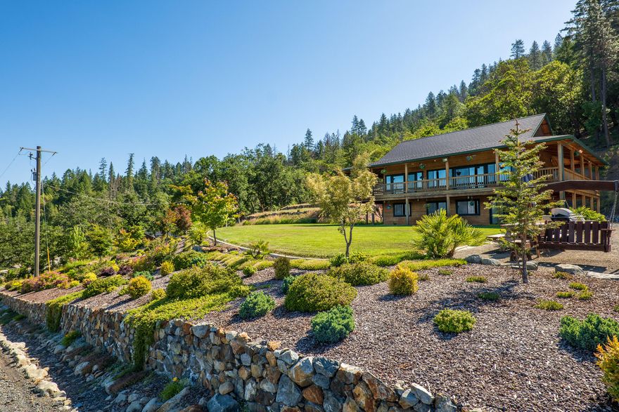 This offering is a true builder's home, with immaculate attention to detail & pride of ownership throughout. From the well-lit gated entry to the polished travertine tile & vertical clear grain woodwork throughout the home, quality is apparent at every turn! The exquisite craftsman home with extensive wraparound decking on both levels sits atop a stately manicured hilltop that includes various shrubbery, flowering trees, & a sprawling lawn upon a stacked stone terrace. It overlooks the valley to the west & features absolutely breathtaking sunsets! A gravity-fed spring & 14K gallons of storage provides domestic water to the home as well as fills the pond to feed the automatic irrigation. Two automatic gates along the entry drive ensure privacy & the neighboring BLM land provides seemingly endless recreation!  Additional features: high end tile work, rare schist counters, surround sound, sound-deadening insulation, hydronic heating, full security system, generator-ready & fully fenced.