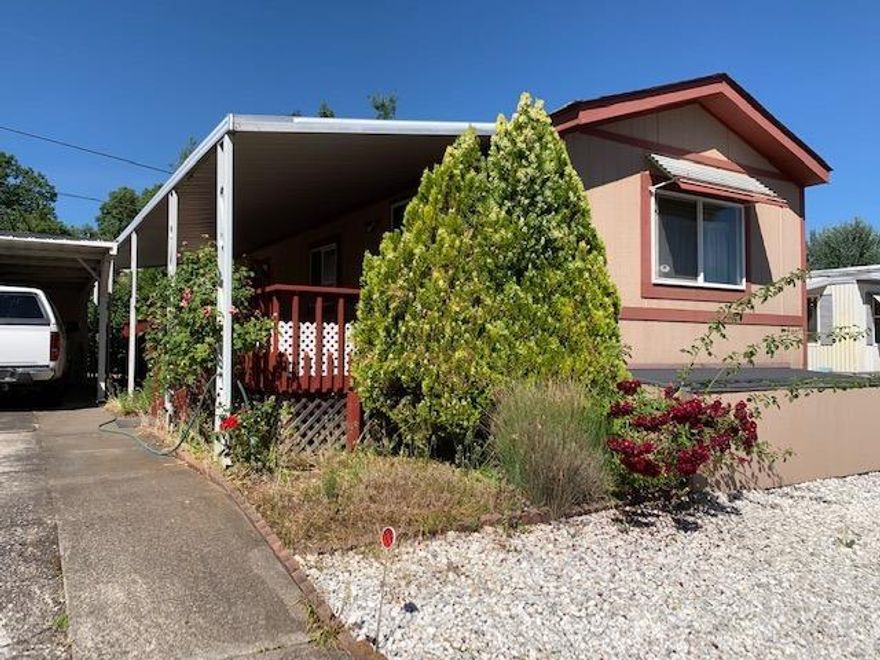 Double Delight! This 2 bdrm, 1 bath home in Royal Oaks, a popular 55+ park in Phoenix, has been seasoned with love and care. Here's a well-maintained 1992 single-wide with a great covered front porch. Enjoy views of the hills and trees from porch and front window. The home has vaulted ceilings and is sunny and clean. An open kitchen has a large island for meal prep that doubles as a breakfast bar. There is room in the kitchen for a table as well. Vinyl windows & new laminate flooring in the living room and hall show the care taken with this home. All the appliances stay in the home. The master bedroom is at the rear of the home. You'll find 2 sheds, 1 under the carport & 1 in the back yard. This is a low maintenance space with rose bushes. Space rent is $483/month including water, sewer & garbage. The park accepts one pet under 20 pounds. Good things do come in small packages. This is one of them.