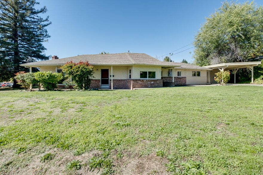 Incredible location on this three bedroom home! This huge .33 acre corner lot sits elevated across the street from the High School in the heart of Grants Pass. The front door opens to a large, bright living room with a fireplace and fresh carpet. The kitchen has been recently upgraded with all new cupboards providing plenty of storage and counter space. Fresh paint and flooring really make this home stand out. Outside, the long driveway leads you to a covered parking area and a storage shed/workshop. This would be a great opportunity for a first time home buyer or investor. Call today to schedule your appointment!