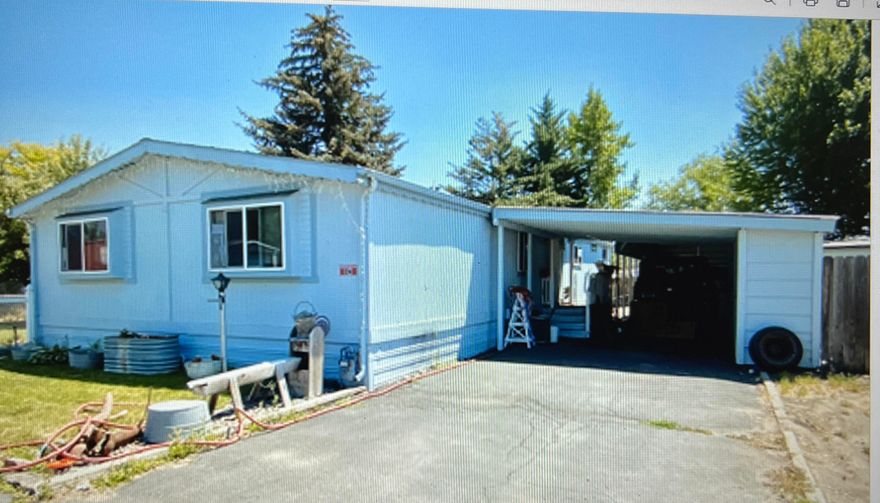 This large manufactured home in the Crest Street Mobile Home Park is at the end of the street with a large fenced yard, covered patio porch, storage sheds, and double length carport with storage cabinets. Living area is spacious, bedrooms are good size, and there is a large laundry room.