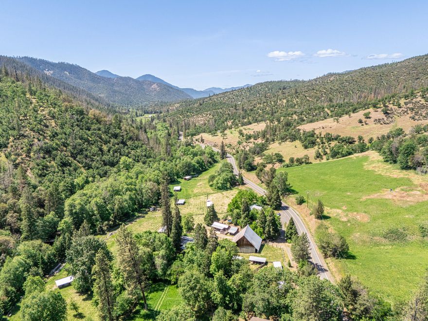 Incredible 119-acre EFU-zoned ranch offering over 1,900 feet of Little Applegate River frontage—an outdoor paradise just 16 miles from downtown Jacksonville. This historic and diverse property includes a 2,080 sq.ft. farmhouse plus a second dwelling: a charming 912 sq.ft. straw bale home, perfect for guests or rental income. The land features an original barn & multiple livestock outbuildings, ideal for farm or ranch operations. 2 Substantial bridges span the river, granting access to both sides of the property. Backing to 1000's of acres of BLM land, the property offers unmatched privacy, recreation, and trail access right out the back gate. Fully fenced and cross-fenced with excellent pasture potential, the property also boasts rare 1885 water rights. Sweeping views, year-round water, and a rich rural character make this a one-of-a-kind Southern Oregon legacy estate. Adjoining parcel also available MLS 220203269 4BR/5BA 5143sqft on 5 acres 1000ft of River frontage.