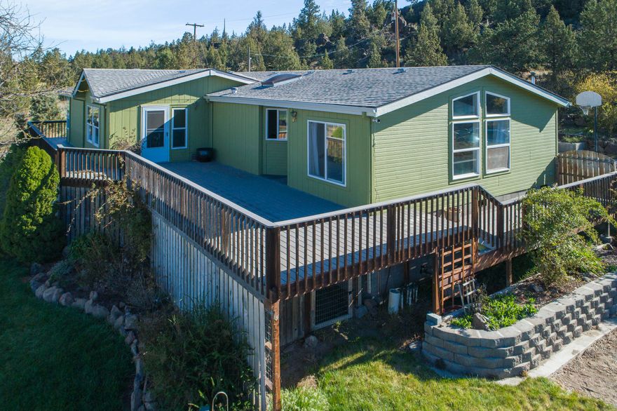 Stunning mountain views! This well-maintained home sits on 5 acres with 4 acres of irrigation. The property showcases an ideal setting with Cascade Mountain views, ample privacy and close proximity to Smith Rock State Park. This spacious 2,334 sqft. single story home includes updated laminate flooring, a large open kitchen with island and eating bar, a living and family room as well as vaulted ceilings. The property is fenced and cross fenced and has an approx. 28'x30' shop with an office area, loft, bonus utility room and bathroom. There's also ample storage under the home and the geothermal heat pump assists in lowering heating and cooling costs. Completing this private paradise is a new irrigation main line with pod sprinklers – the irrigation system is private and the owners irrigate 24/7 from the COI canal. This property would make a wonderful vacation rental or second home and the garage with adjacent bathroom may have potential as an ADU.