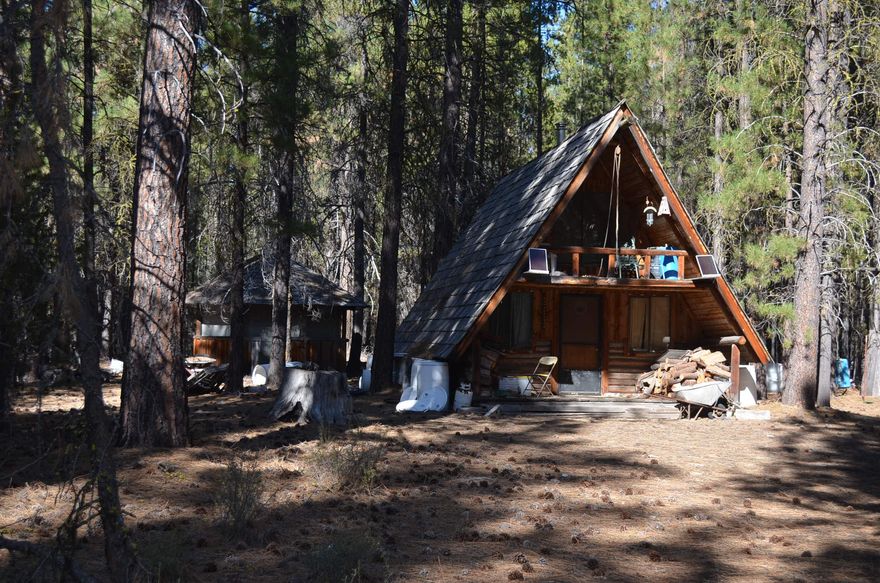 20 treed acres that are private and peaceful with a hunter's cabin.  Located in the Schoonover area south of Crescent.  In a great area for camping, hunting, riding quads and snowmobiling.  Hunter's cabin features a bedroom upstairs with a living and dining area downstairs.  Cabin has solar panels and a rain water collection system.  There is also a covered shelter area that could have many uses.  This property makes for a relaxing getaway or a great place to enjoy with friends and family.  GPS coordinates 43.41865, -121.75517