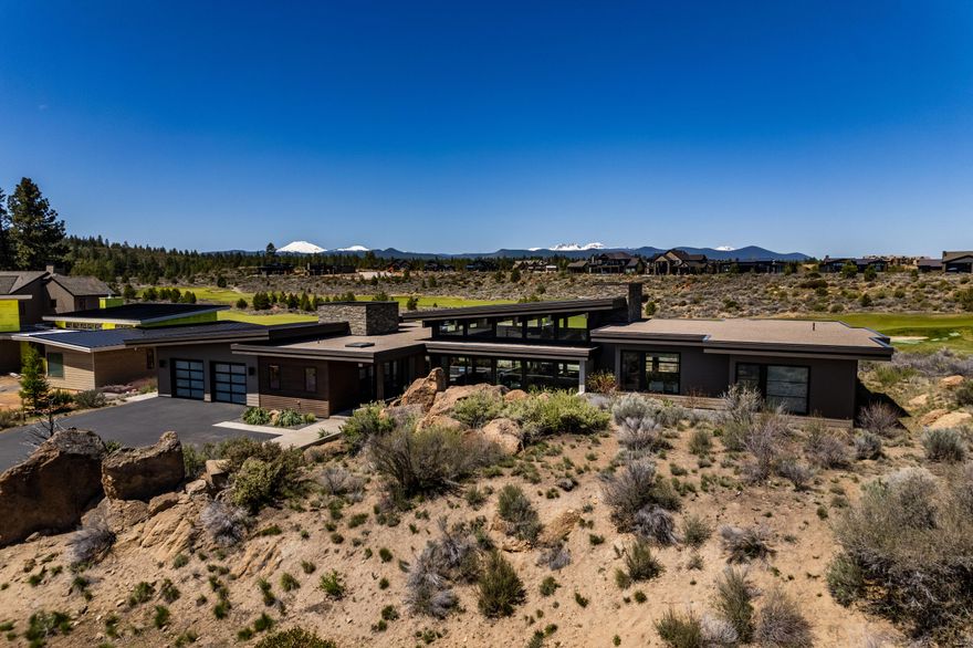 Situated on Tetherow's 4th fairway with incredible views of the Cascade Mountains, this one level, high end, custom built home by renowned High Timber has an excellent floor plan, abundance of natural light, soaring ceilings, and designer details and finishes. Located on a private gated cul de sac and thoughtfully designed to create an indoor/outdoor ambiance with perfect sun orientation creating a soothing retreat from every room. Features include stainless appliances, automated sound lighting & curtains, outdoor shower, in-ground hot tub, gas fire pit,  floor to ceiling windows, and a large great room.  This thoughtful floorplan also offers 3 Bedrooms, 3.5 Baths, a Bonus Room and an Office.