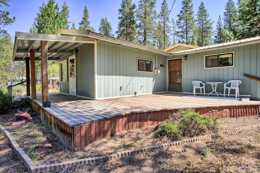 Charming 2 bedroom, 1 bath home on 1+ acre lot with everything you need! There is an adjacent studio with half-bath which allows for endless possibilities! The home lives large with an open living room plan plus a family room. The breeze way runs between the home and detached over-sized, two-car garage with shop and storage. The front deck is covered, and the spacious wood deck wraps around one side of the home. There are two additional storage buildings and a partially enclosed shelter for boat storage for your outdoor equipment and more. Home is currently on its own well and septic, but is fully prepared to connect with future city water and sewer. Wonderful location is convenient to Hwy 97 and Forest Service land, offering year round access to many beautiful lakes and trails.