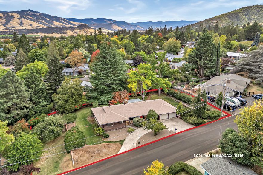 Charming single-level midcentury home on a huge 0.4-acre lot with mature trees located above the boulevard, just nine minutes to Ashland's downtown plaza! Versatile floor plan with original oak hardwood floors, front living room and formal dining room, informal dining area with built-in buffet and sliding glass door to covered brick patio. Kitchen with wood cabinets, stainless double sink, electric range oven with hood, second oven, dishwasher, and refrigerator. Primary bedroom with ceiling fan, dual closets, and ensuite access to full bathroom with tiled vanity, vintage fixtures, and sunken tub shower with tiled surround. Second bedroom or office with built-in shelving, closet, and ceiling fan. Family room or potential third bedroom with wood-paneled walls and wood-burning fireplace with stone surround. Pantry mudroom with built-in cabinets, washer, dryer, exterior door to backyard, full bathroom with shower, and two-car garage with insulated bay doors. Inquire for details!