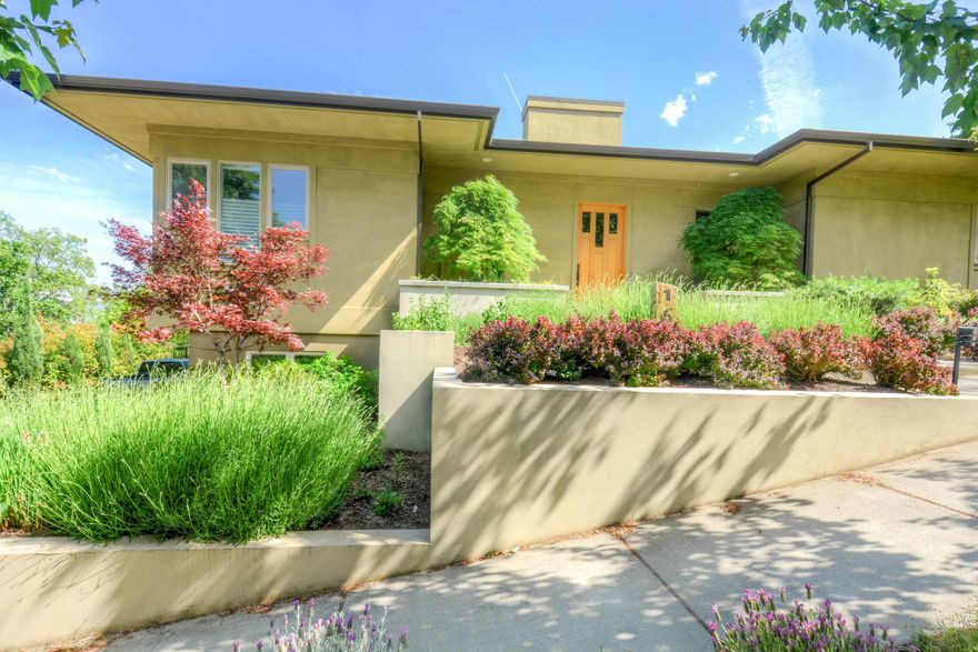 This exceptional contemporary residence offers a harmonious blend of sophisticated design and functionality, perfectly situated just minutes from the Plaza. The main level boasts a luxurious primary suite with a double-sized steam shower and a very large walk-in closet with a washer/dryer. The main level also features a guest suite. The 3rd bedroom is on the lower level with easy access to the backyard. Radiant floors thru out this home with 5 zones. Home has geo-thermal heating & AC. Elegant use of cement flooring and vast walls of glass. The gourmet kitchen seamlessly flows into the expansive living areas, making it ideal for entertaining. The large patio offers breathtaking views towards the iconic Shakespeare Festival and the valley. The property is enhanced by a lovely garden providing a serene oasis. Practicality meets luxury with an oversized garage with gym space, storage, extra washer/dryer hook up. This home truly embodies contemporary elegance, it is an entertainer's dream.