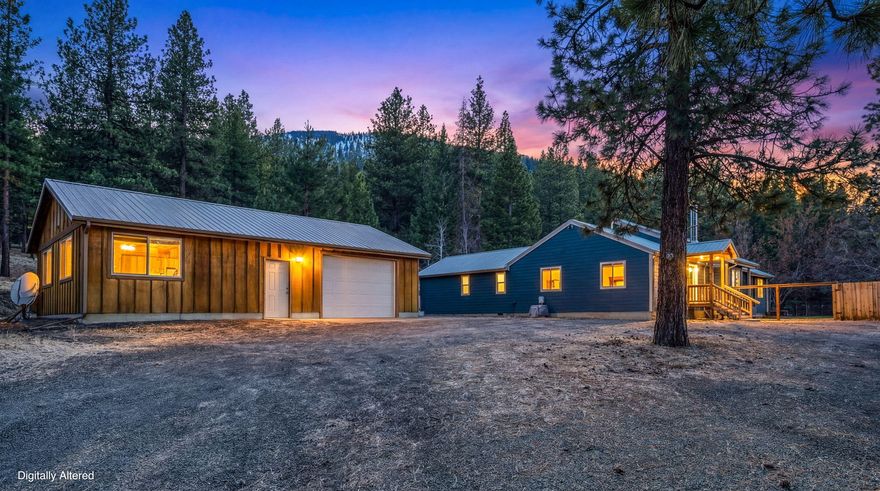 Beautiful five-acre property nestled in the pines and bordering BLM land, offering privacy and access to the outdoors. This 2,412 sq ft home features four bedrooms and three bathrooms with pine accents throughout. The main primary suite includes a sliding glass door to the covered back deck, double vanity, soaking tub, tile shower, and walk-in closet. A second primary suite offers a shower surround and closet with bypass barn doors. Stay comfortable year-round with a Blaze King woodstove and a ducted heat pump. The 1,040 sq ft detached garage/shop includes a concrete floor, insulation, sheetrock, 220 power, and an oil monitor stove. Additional features include a 12′ x 10′ hickory storage shed, fenced backyard for pets, partial perimeter fencing, well, septic system, backup generator wired to the house, and a circular driveway. This property is situated only a few minutes away from town.