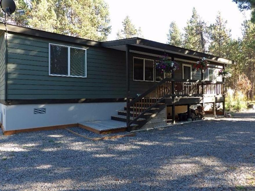 Charming 3 bedroom/2 bathroom updated manufactured home on .87 acre wooded corner lot is across the street from the Deschutes River. River access within walking distance in two directions. Upgrades: Granite counter tops, stainless appliances, back splash, hardwood floors, energy efficient windows, ceramic tile in bathrooms, carpet in 2 bedrooms. Covered front porch and back deck. Fenced backyard. Certified wood stove. Garden shed for storage. Room to park RV. Semi-circle drive. Owner real estate licensee.