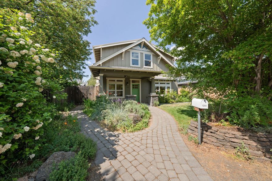 Ideally located on Bend's west side, this charming custom home is just steps from the river, shops and restaurants on Century/14th, and less than a mile to downtown via the Columbia Park pedestrian bridge. Designed with sustainability and comfort in mind, it features a 3.6 kW solar system, concrete floors with radiant heat on the main level and upstairs baths, and an air filtration system. The great room offers a cozy gas fireplace flanked by built-ins while the adjacent dining area and kitchen, complete with updated appliances, are filled with natural light. A main-level flex room with closet functions as a bedroom or office. Upstairs you'll find two spacious bedrooms, a full bath, and the primary suite with adjacent bonus room - ideal as a gym or private retreat. The lushly landscaped, fully fenced yard offers side yard storage and the oversized, heated two-car garage is complemented by additional parking space in back for a small RV or boat. West side living at its best!