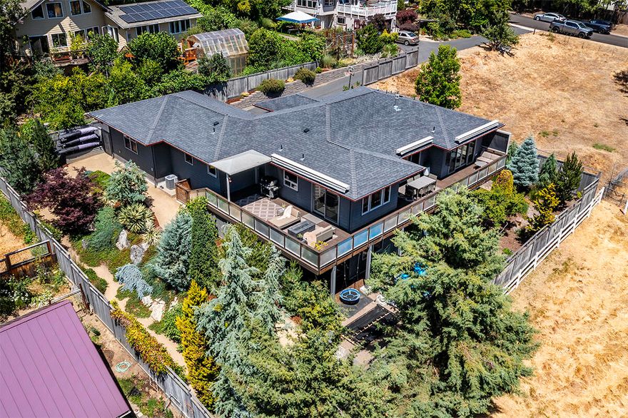 Gorgeous, architecturally designed contemporary home nestled in the hills of Ashland, Oregon. This sophisticated 3 bed, 2.5 bath is beautifully appointed w/luxury systems & upgrades throughout including hardwood floors, designer lighting & floor to ceiling glass doors. Main level primary suite w/private deck access, ceiling treatments & spa like ensuite featuring a floating dual sink vanity, walk-in shower, tile floors & freestanding soaking tub. Chef's designer kitchen equipped w/a commercial grade hood fan, Thermador 6 burner range w/double ovens, expansive quartz waterfall island & full height penny tile backsplash. The lower level includes 2 bedrooms, a bonus room, full bathroom & family room plus an elegant, temperature-controlled wine room.  Dedicated laundry/mud room & a formal office area outfitted w/a commercial grade glass door. 2-car garage w/storage & EV hookup. Oversized .26-acre lot w/tons of privacy, easy-care landscaping & fantastic views of the surrounding mountains!