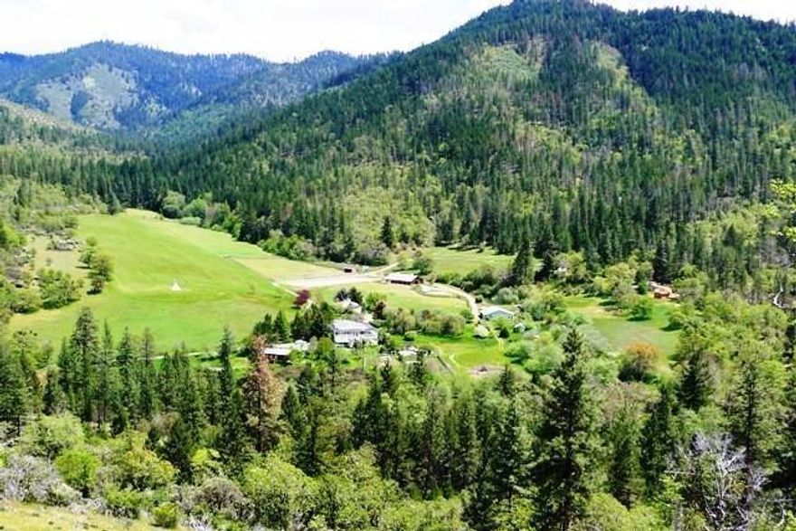 Excellent Grow Opportunity, EFU, multiple tax lots & water rights! 90 acre paradise w/ multiple dwellings offers a variety of living. Remodeled main home of 3808 sq.ft. with complete 2 family living. Remodeled single level 2 bd/ 2bth second home on knoll setting w/ views of pasture & mtns. Detached 3 car garage w/ private studio & bth. Strawbale village w/ 3 separate sleeping units, sauna bath house & central kitchen. Cute mobile cottage w/ private deck overlooking small meadow & 2 more units in a private treed setting up the hill. This property offers approx. 30 acres of open pasture w/ remaining in woods & meadows. Approx. 6 ac under irrigation. Large irrig pond w/ system fed by creek & well. Beautiful 4 stall horse barn w/ living quarters, tack room, feed stall & h/c wash & dry rack. Floor is fully matted & has a large riding arena off to the side. Custom greenhouse, fenced organic gardens, irrig landscaping & seasonal waterfall to visit on one of your many hikes or rides.