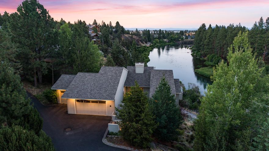 Enjoy unobstructed views from 7 decks & multiple rooms in this stunning home towering above the Deschutes River, just a short distance from 1st ST Rapids Park, Downtown Bend, & Newport Ave. Primary on the main living boasting cherry wood floors & cabinets, 10-ft coffered ceilings premium Dacor appliances & towering windows w/ views from the kitchen, dining, living, & primary bedroom! A spacious primary suite w/ tall ceilings, gas fireplace, a massive walk-in closet, steam shower, & private river view deck w/hot tub. Downstairs a large media room awaits complete with a 120-in movie screen, projector, wet bar, remote blackout shades & 2 decks towering above the Deschutes.  An ensuite is perfect for guests or multi-generational living. Two additional bedrooms boast river views, & a large bonus room serves as an ideal rec/craft room space. Other features include built-in speakers throughout, office, 3-car garage, & central vac system & river trail access.