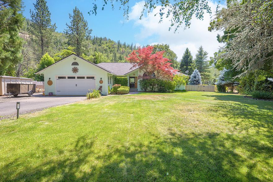 Located just outside of Shady Cove is this beautiful home that offers a serene, park-like setting with over 100' of stunning Rogue River frontage! The fabulous back deck is the perfect spot to entertain or relax and take in all the sights and sounds of nature. Inside, you'll find updates throughout, including a new roof, fresh interior paint, new flooring, and remodeled bathrooms. The inviting living room features a vaulted ceiling and lovely curved window, while a woodstove in the family room adds charm and warmth during cooler months. The kitchen boasts granite counters, new appliances, and breakfast nook. Natural light fills the space through big windows that frame picturesque views in every direction! The primary suite is a retreat with French doors that open wide to the back deck and bring the outdoors in. Property is gated/fenced, and includes RV hookups, a shed, catio, and plenty of parking. Make this truly gorgeous property yours and come live like you're on vacation everyday!